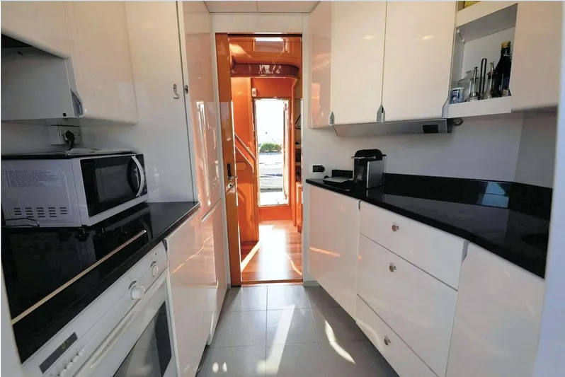  Yacht Photos Pics Modern kitchen interior on a 1998 Sanlorenzo 62 yacht, featuring sleek white cabinetry.