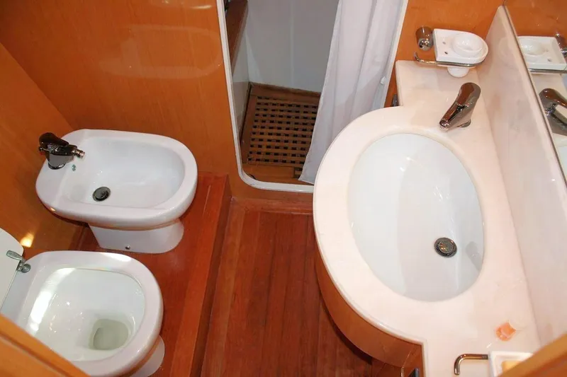  Yacht Photos Pics Bathroom interior of 1998 Sanlorenzo 62 yacht with sink, toilet, and bidet.