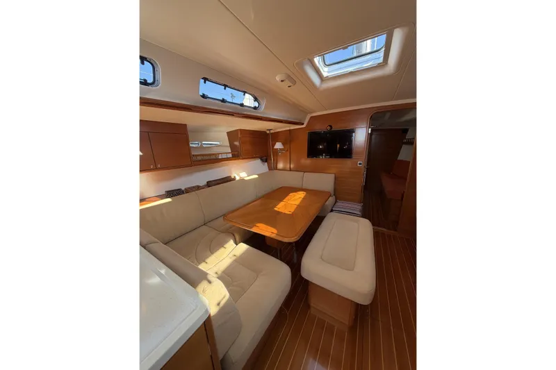 Heartbreaker Yacht Photos Pics Luxurious interior of 2011 X-Yachts X-55 sailboat with elegant wood finish and plush seating.