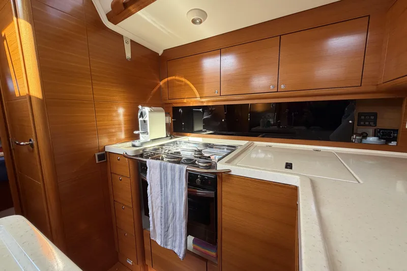Heartbreaker Yacht Photos Pics Luxurious 2011 X-Yachts X-55 yacht kitchen with wooden cabinetry and modern appliances.