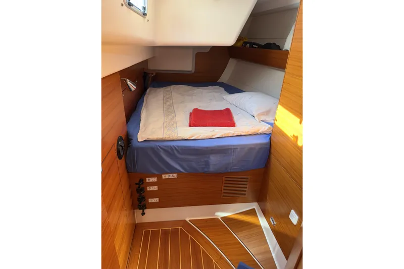 Heartbreaker Yacht Photos Pics Cozy cabin interior of 2011 X-Yachts X-55 with wooden finish and comfortable bedding.