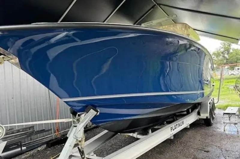  Yacht Photos Pics 2017 Scout 350 LXF boat in blue on a trailer under a canopy.