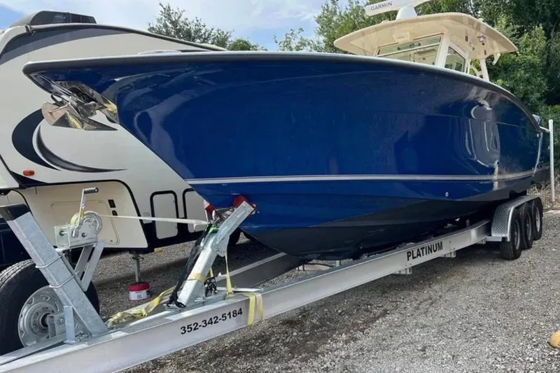  Yacht Photos Pics 2017 Scout 350 LXF boat on trailer, blue hull, parked outdoors.