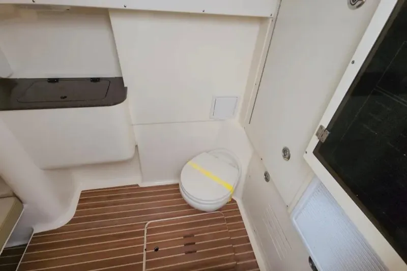  Yacht Photos Pics 2017 Scout 350 LXF boat interior with wooden flooring and compact toilet.