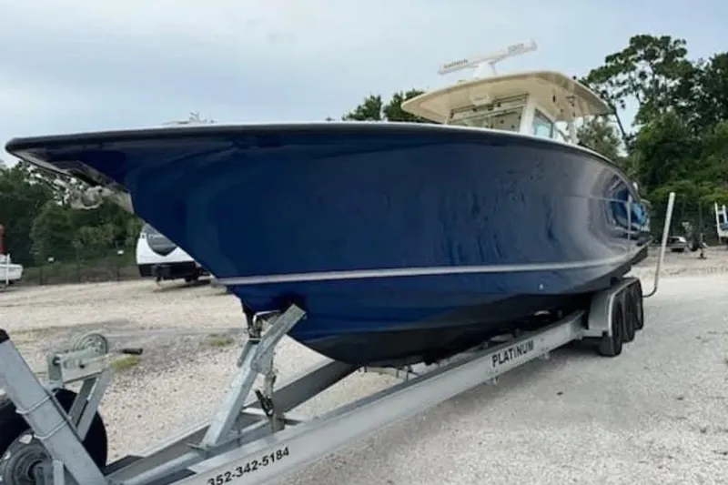  Yacht Photos Pics 2017 Scout 350 LXF boat on trailer, side view, blue hull.
