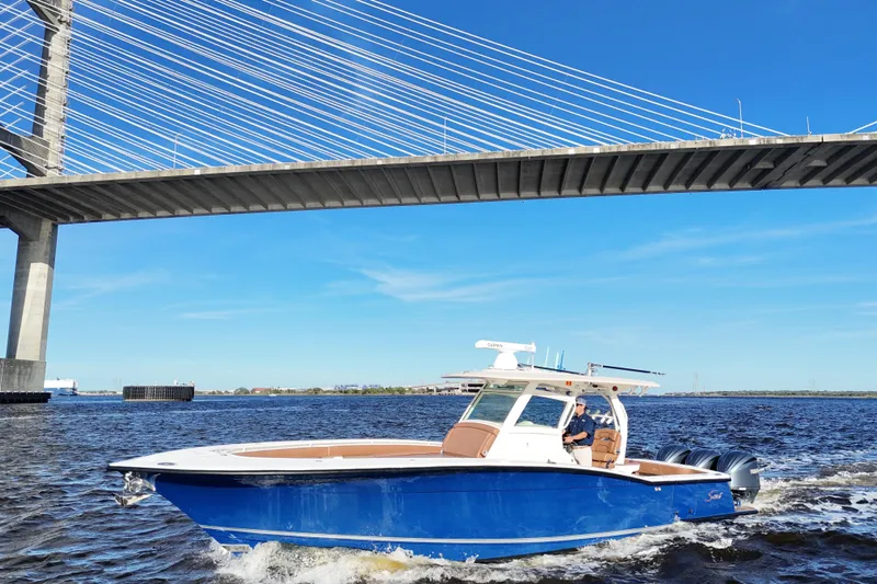  Yacht Photos Pics 2017 Scout 350 LXF boat cruising under a bridge on a sunny day.