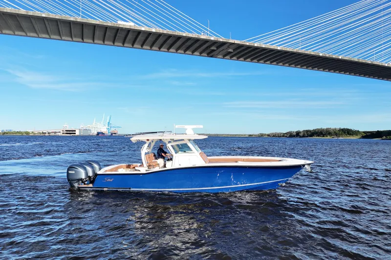  Yacht Photos Pics 2017 Scout 350 LXF boat cruising under a bridge on a sunny day.