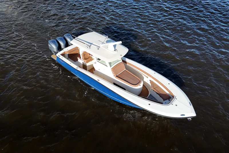  Yacht Photos Pics 2017 Scout 350 LXF boat cruising on open water, featuring triple outboard engines.