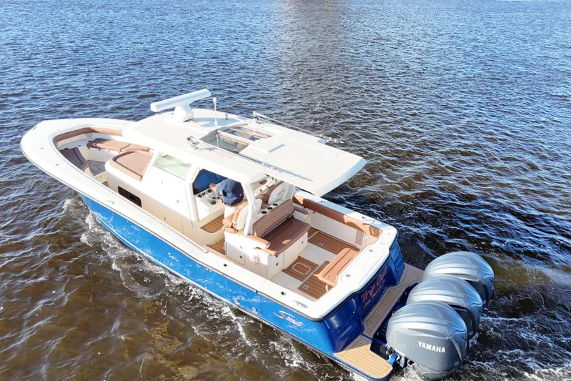  Yacht Photos Pics 2017 Scout 350 LXF boat cruising on water with triple Yamaha engines.