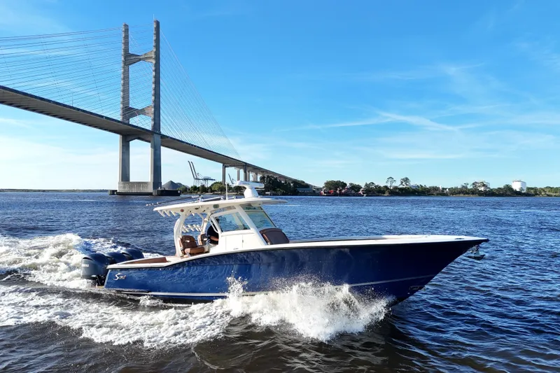  Yacht Photos Pics 2017 Scout 350 LXF boat cruising under a bridge on a sunny day.