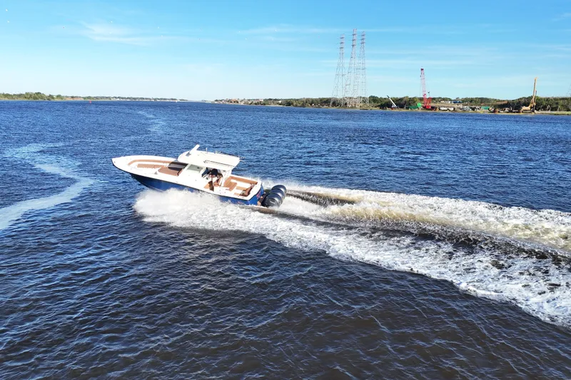  Yacht Photos Pics 2017 Scout 350 LXF boat cruising on a sunny day, creating waves in the water.