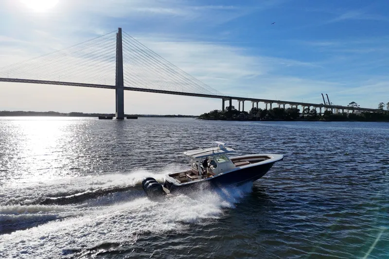  Yacht Photos Pics 2017 Scout 350 LXF boat cruising under a bridge on a sunny day.