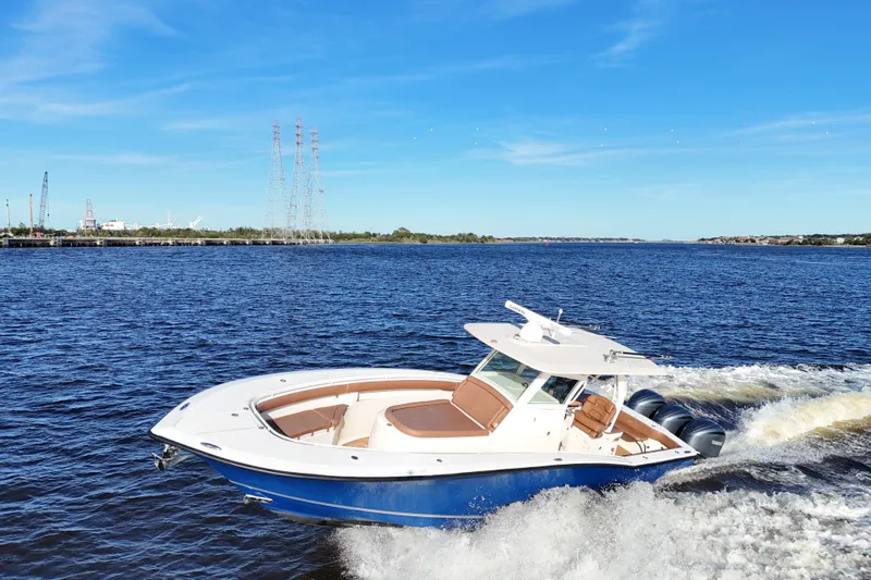  Yacht Photos Pics 2017 Scout 350 LXF boat cruising on a sunny day, blue water and sky backdrop.