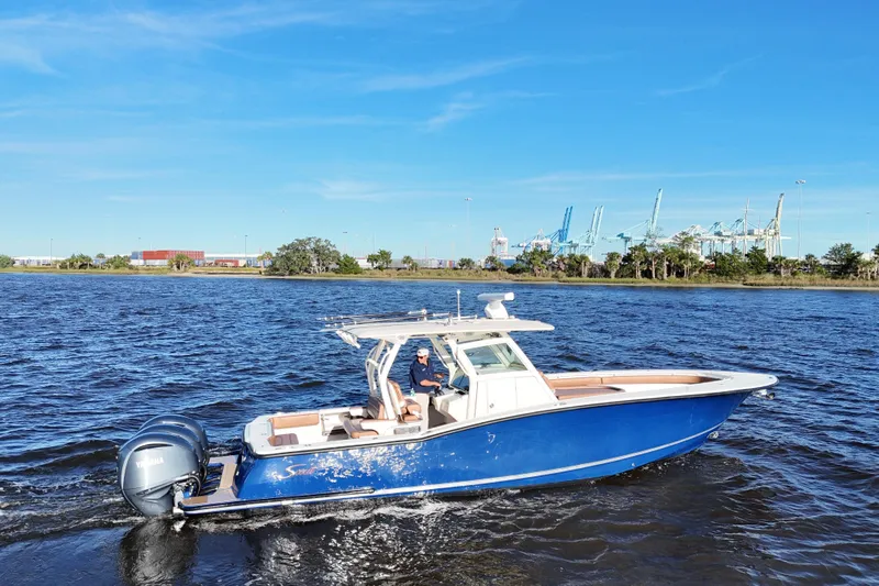  Yacht Photos Pics 2017 Scout 350 LXF boat cruising on a sunny day with industrial background.