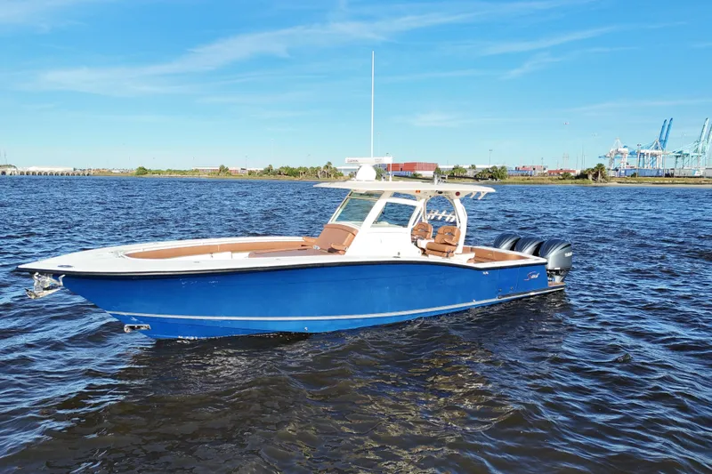  Yacht Photos Pics 2017 Scout 350 LXF boat on water, blue hull, clear sky, industrial background.