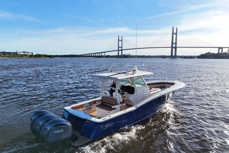  Yacht Photos Pics 2017 Scout 350 LXF boat cruising near a bridge on a sunny day.