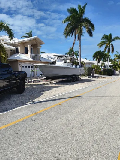 ___ Yacht Photos Pics 2018 Sea Hunt Gamefish 30 boat on trailer, parked near palm trees and houses.