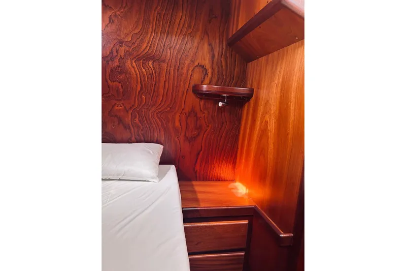 Aria Di Mare Yacht Photos Pics Cozy wooden cabin interior of 2013 Custom Classic Yawl with bed and warm lighting.