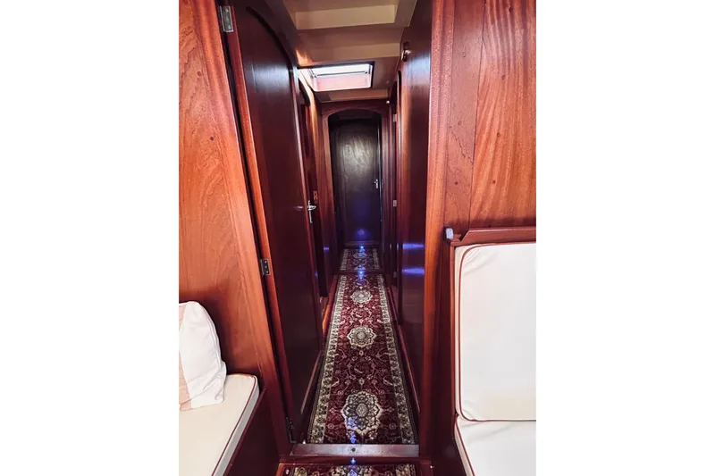 Aria Di Mare Yacht Photos Pics Interior of a 2013 Custom Classic Yawl with wooden paneling and ornate carpet.