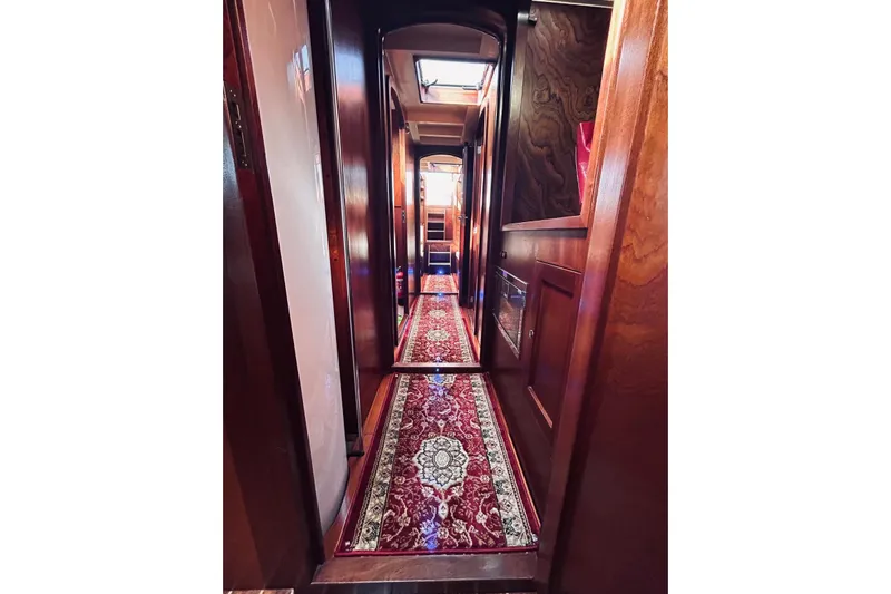 Aria Di Mare Yacht Photos Pics Interior hallway of 2013 Custom Classic Yawl with elegant wood paneling and ornate carpet.