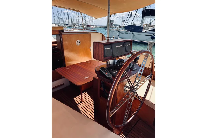 Aria Di Mare Yacht Photos Pics Steering wheel and controls of a 2013 Custom Classic Yawl in a marina setting.