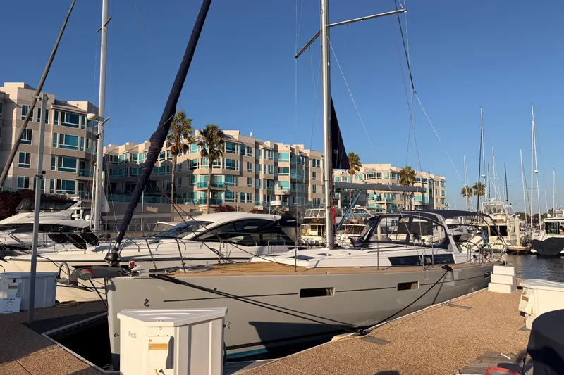 Bella Yacht Photos Pics 2017 Beneteau Oceanis 45 sailboat docked at marina with modern buildings in background.