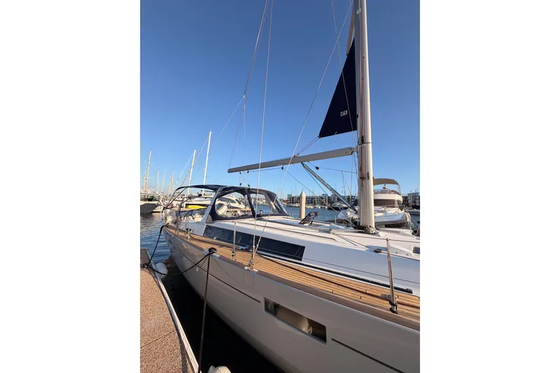 Bella Yacht Photos Pics 2017 Beneteau Oceanis 45 sailboat docked at marina under clear blue sky.