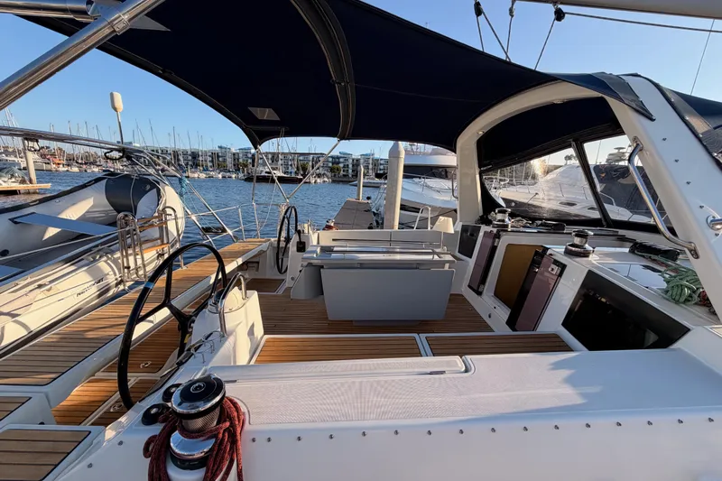 Bella Yacht Photos Pics 2017 Beneteau Oceanis 45 sailboat cockpit with wooden deck and marina view.