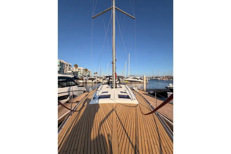 Bella Yacht Photos Pics 2017 Beneteau Oceanis 45 sailboat docked at a marina under clear blue skies.