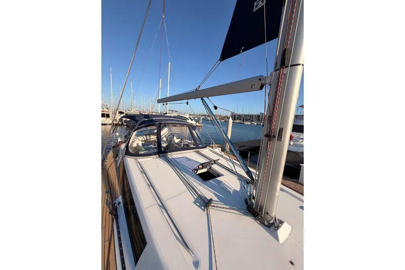 Bella Yacht Photos Pics 2017 Beneteau Oceanis 45 sailboat docked at marina, clear sky, calm waters.