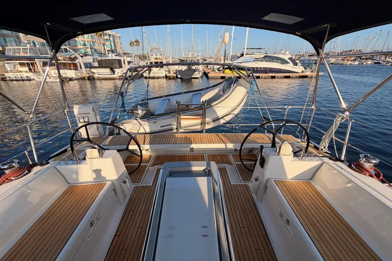 Bella Yacht Photos Pics 2017 Beneteau Oceanis 45 sailboat cockpit with dual steering wheels, docked in a marina.