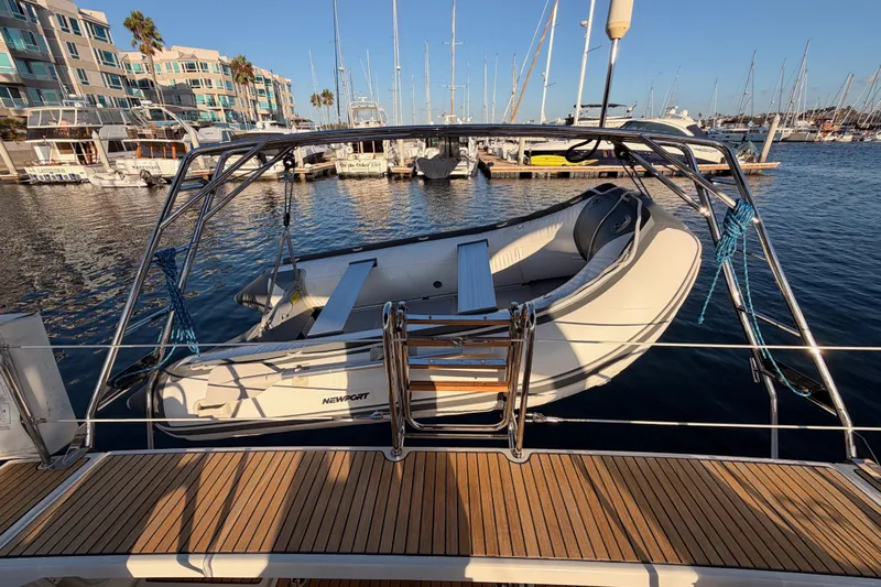 Bella Yacht Photos Pics Beneteau Oceanis 45 (2017) with dinghy at marina, surrounded by yachts and waterfront buildings.