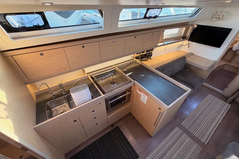 Bella Yacht Photos Pics Modern kitchen interior of 2017 Beneteau Oceanis 45 yacht with sleek cabinetry and appliances.