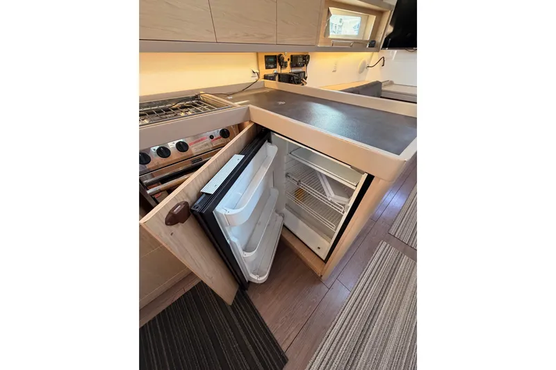 Bella Yacht Photos Pics Interior of 2017 Beneteau Oceanis 45 yacht kitchen with open fridge and stove.