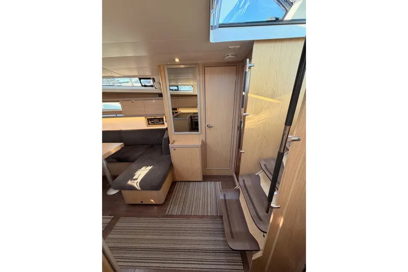Bella Yacht Photos Pics Interior of 2017 Beneteau Oceanis 45 yacht, featuring modern wood finishes and cozy seating area.