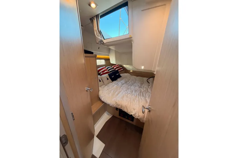 Bella Yacht Photos Pics Cozy cabin interior of 2017 Beneteau Oceanis 45 sailboat with bed and window.