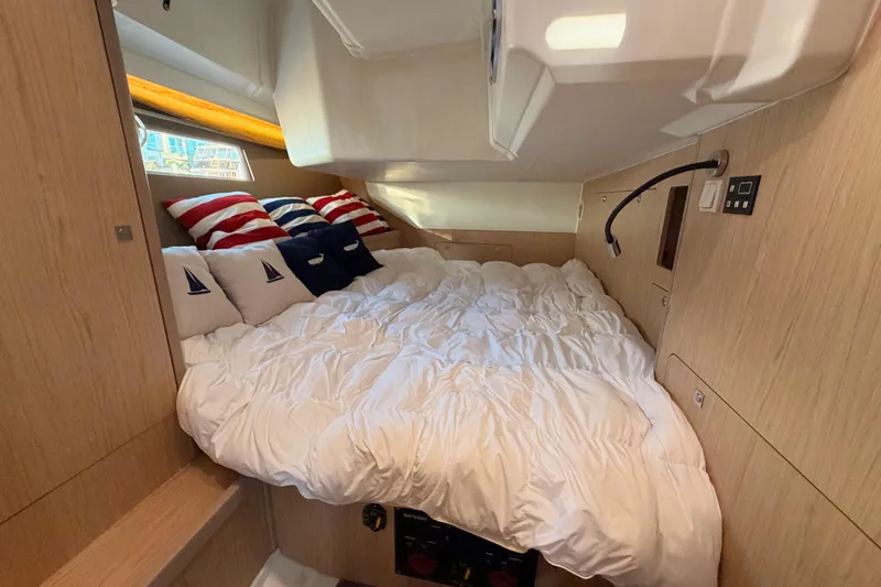 Bella Yacht Photos Pics Cozy cabin interior of 2017 Beneteau Oceanis 45 with nautical-themed bedding.