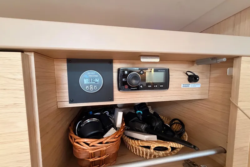 Bella Yacht Photos Pics Interior of 2017 Beneteau Oceanis 45 yacht with control panel and storage baskets.