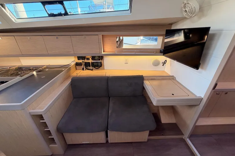 Bella Yacht Photos Pics Interior of 2017 Beneteau Oceanis 45 yacht with seating, table, and TV.