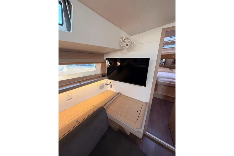 Bella Yacht Photos Pics Interior of 2017 Beneteau Oceanis 45 yacht with TV, desk, and cozy seating area.
