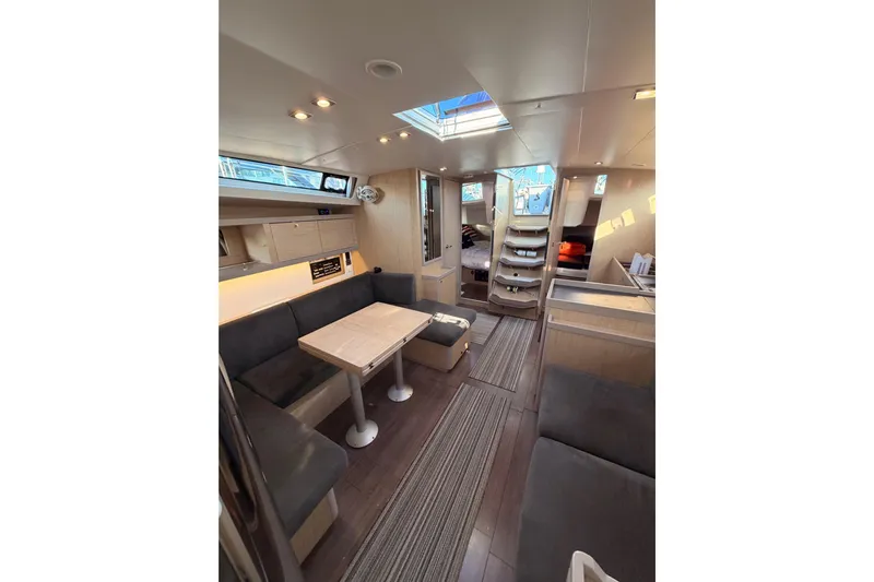 Bella Yacht Photos Pics Interior of 2017 Beneteau Oceanis 45 yacht, featuring modern seating and dining area.