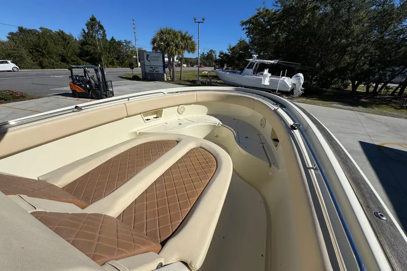  Yacht Photos Pics 2019 Chris-Craft Catalina 30 boat interior with tan cushioned seating, parked outdoors.