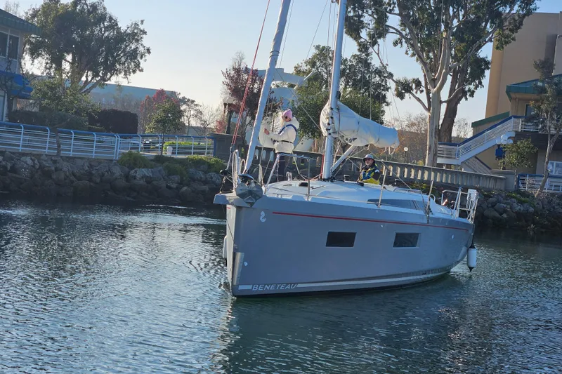 Cutting Edge Yacht Photos Pics 2023 Beneteau Oceanis 34.1 sailboat docked near a scenic waterfront.