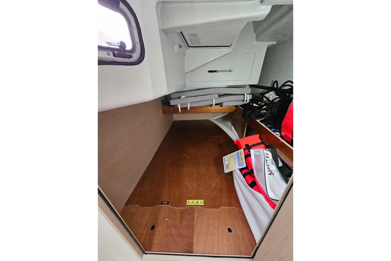 Cutting Edge Yacht Photos Pics Interior storage space of 2023 Beneteau Oceanis 34.1 sailboat, featuring life jackets and equipment.
