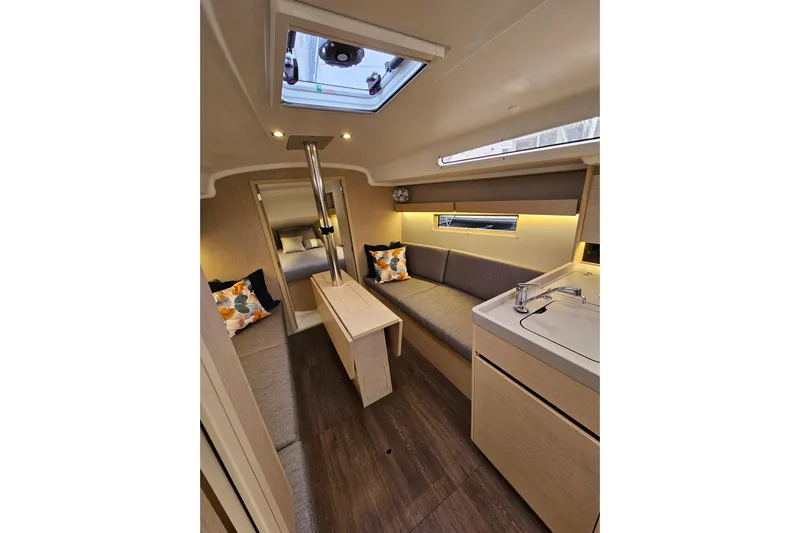 Cutting Edge Yacht Photos Pics Interior of 2023 Beneteau Oceanis 34.1 yacht, featuring modern seating and compact kitchen.