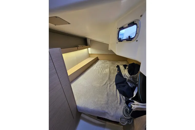 Cutting Edge Yacht Photos Pics Cozy cabin interior of 2023 Beneteau Oceanis 34.1 sailboat with window and bedding.