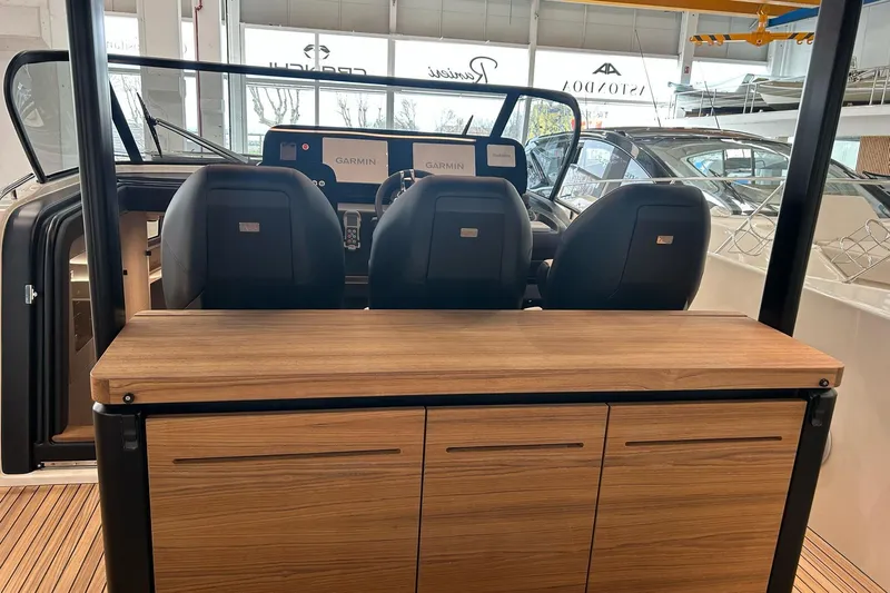  Yacht Photos Pics 2024 Cranchi A46 Luxury Tender cockpit with wooden cabinetry and modern navigation displays.