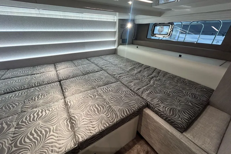 Yacht Photos Pics Luxurious interior cabin of 2024 Cranchi A46 Luxury Tender with patterned bedding.