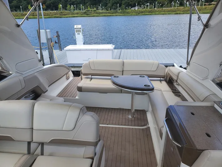  Yacht Photos Pics 2015 Formula 330 Crossover Bowrider interior with seating and table, docked by a lake.