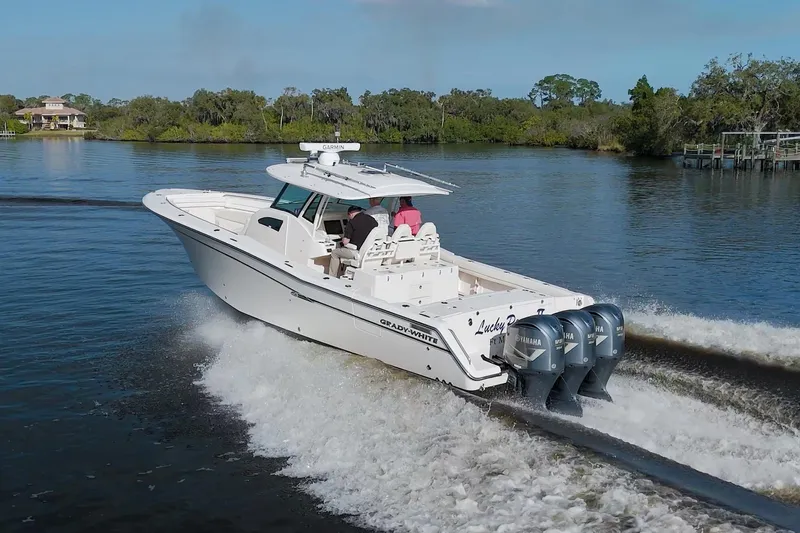 Lucky Penny II Yacht Photos Pics 2018 Grady-White Canyon 376 boat cruising on a serene lake.